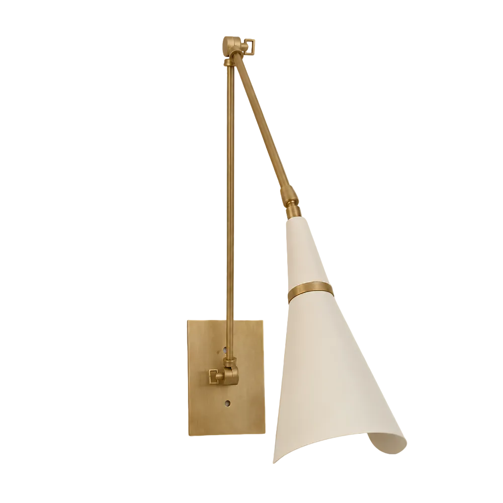A modern wall sconce with a warm brass adjustable arm and a tapered off-white shade, shown against a solid light gray background.